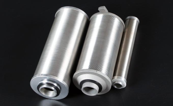 Three stainless steel notch wire filter cartridges showing cylindrical slot surfaces and machined end fittings